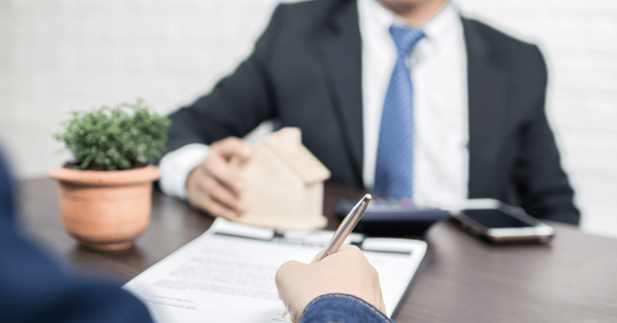 Investor reviewing and signing a mortgage agreement with a lender, representing how real estate investors compare lending options based on speed, flexibility, and rate.